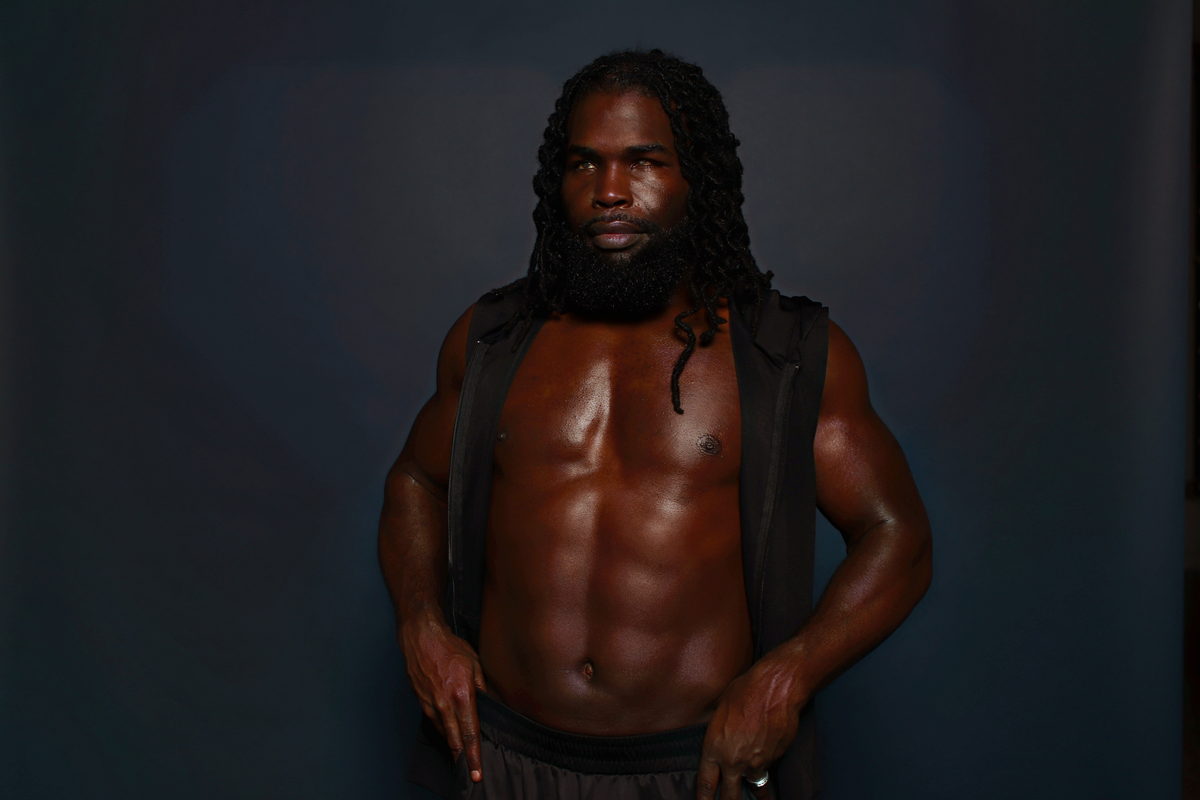 Studio dark, open vest, frontal stance.